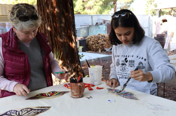 SCC student and faculty coloring butterflies for mural